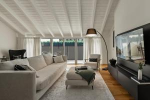 a living room with a white couch and a tv at The Como City Golden Loft by Aura Luxury Collection in Como