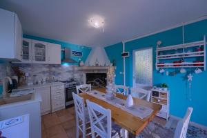 a kitchen with blue walls and a table and chairs at Villa Biankura in Blato +50 photos