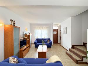 ein Wohnzimmer mit einem blauen Sofa und einem Fernseher in der Unterkunft Cosy house near the beaches #1978 in Aljezur