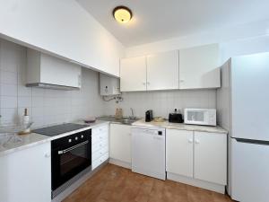 eine weiße Küche mit weißen Schränken und Geräten in der Unterkunft Cosy house near the beaches #1978 in Aljezur