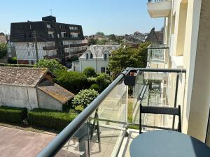 a person is standing on the balcony of a building at Studio Central à Cabourg avec Balcon, Wifi Gratuit & Parking - FR-1-487-372 in Cabourg +3 photos