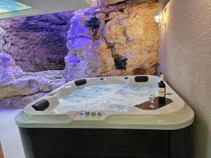 a bath tub in a room with a rock wall at וילה לוזון - וילה מדהימה עם בריכה פרטית מחוממת ומקורה בכרם בן זמרה in Kerem Ben Zimra