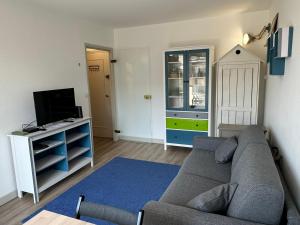 a living room with a couch and a tv at Studio Central à Cabourg avec Balcon, Wifi Gratuit & Parking - FR-1-487-372 in Cabourg