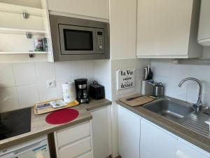 a kitchen with a sink and a microwave at Studio Central à Cabourg avec Balcon, Wifi Gratuit & Parking - FR-1-487-372 in Cabourg