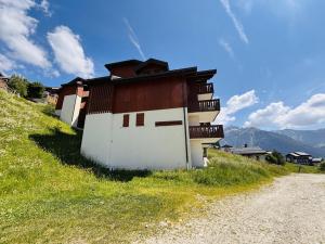 a building on the side of a grassy hill at Appartement 4 pièces avec PARKING, animaux admis, accès pistes - 6 pers, Vallandry - FR-1-757-115 in Landry +7 photos