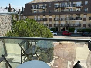 a balcony with a chair and a building at Studio Central à Cabourg avec Balcon, Wifi Gratuit & Parking - FR-1-487-372 in Cabourg