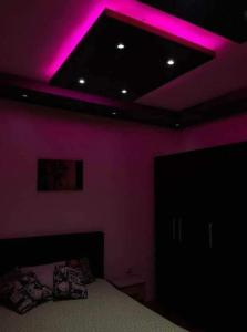 a bedroom with purple lights on the ceiling at Lola Jagodina in Jagodina