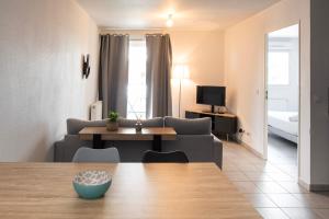 a living room with a couch and a table at Appart Romarin - Proche Gare & Stadium in Miramas