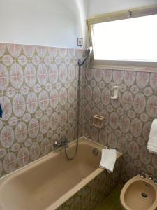 a bathroom with a bath tub and a toilet at Hôtel Restaurant Brasilia in Cagnes-sur-Mer