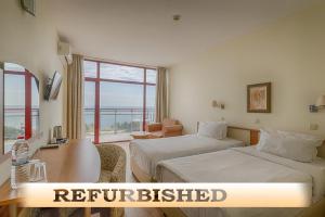 una camera d'albergo con due letti e una finestra di Helios Spa Hotel- All Inclusive , Newly Refurbished Rooms with Private AC, Pools and Water Fun for Kids a Golden Sands