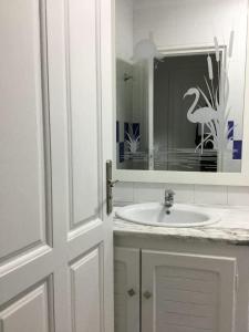 Un baño con un lavabo blanco y un espejo. en Romance d'été, en Hammam Sousse