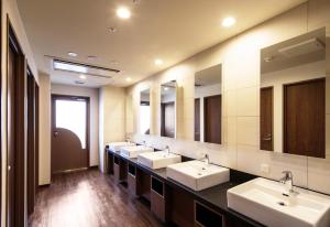 a bathroom with two sinks and a large mirror at MyCUBE by MYSTAYS Asakusa Kuramae in Tokyo