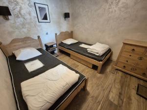 a room with two beds and a wooden dresser at Bel appartement moderne 8 pers, 250m des pistes - FR-1-811-24 in Les Deux Alpes
