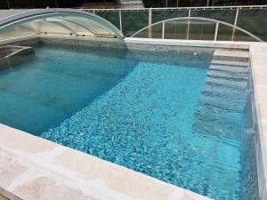 a large swimming pool with blue water at Parenthèse à la Maison de Gilda in Eygalières