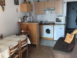 a kitchen with a washing machine and a microwave at Studio avec loggia panoramique à Super Besse, accès pistes à 300m - FR-1-814-30 in Besse-et-Saint-Anastaise