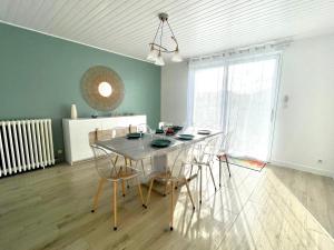a dining room with a table and chairs and a window at Maison rénovée 3 chambres, proche centre et plage, jardin, parking - FR-1-231-332 in Brétignolles-sur-Mer +18 photos