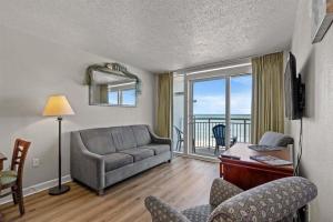 a living room with a couch and a table with chairs at Spacious 2 bedroom Direct Ocean Front Condo, Corner Unit, Balconies HSS 5th FL in Myrtle Beach
