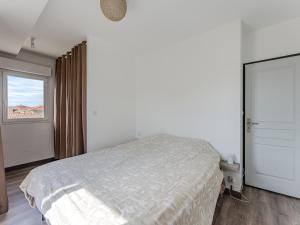 a white bedroom with a bed and a window at Maison spacieuse à Biscarrosse-Plage près de l'océan - FR-1-521-251 in Biscarrosse