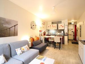 a living room with a couch and a kitchen at Studio 26m² au centre de La Bourboule avec WIFI, proche des Thermes - FR-1-415-157 in La Bourboule