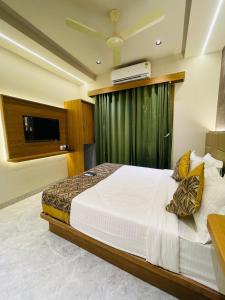 a bedroom with a large bed and a television at Glitz T2 Grand-Next to Intl Airport in Mumbai +17 photos