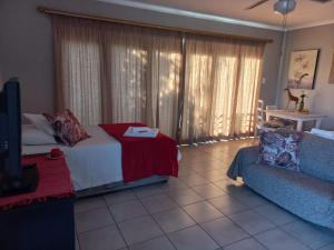 a living room with a bed and a couch at 109 Mauser Avenue in Pretoria