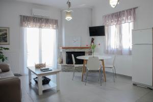 a living room with a table and a fireplace at Georgia's House in Galatas