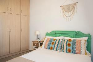 a bedroom with a bed with a green headboard at Georgia's House in Galatas