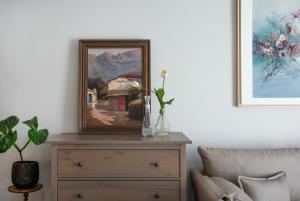 a painting sitting on top of a dresser in a living room at Georgia's House in Galatas