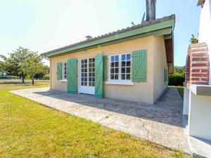 Une petite maison avec volets verts dans l'établissement Maison 6 pers à Vielle-Saint-Girons - Jardin et parking - FR-1-50-186, à Vielle-Saint-Girons