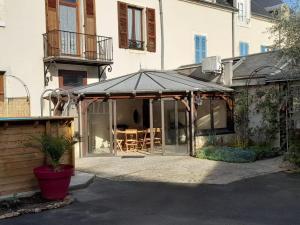 a patio with a black umbrella and a table at Maison familiale avec piscine privée à Saint-Gaultier - FR-1-591-752 in Saint-Gaultier