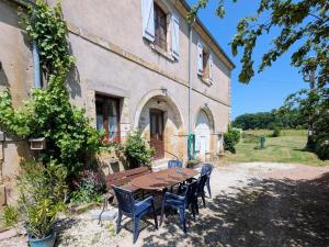 a table and chairs in front of a building at Gîtes de caractère avec jardins au cœur de la nature, idéal pour familles et amis - FR-1-583-505 in Montigny-les Cherlieux