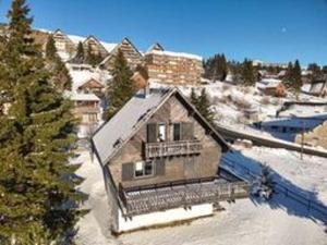 a large house in the snow with trees in the background at Chalet rénové pour 10 pers. avec Parking proche Super Besse - FR-1-814-102 in Besse-et-Saint-Anastaise