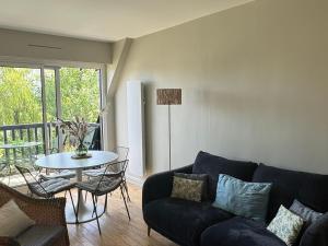 a living room with a couch and a table at Appartement Duplex 2 Pièces Centre-Ville avec Balcon et Internet Inclus - FR-1-487-383 in Cabourg +7 photos