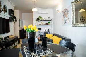 a living room with a table with yellow flowers on it at Apartamento Dubai By Garvetur in Quarteira