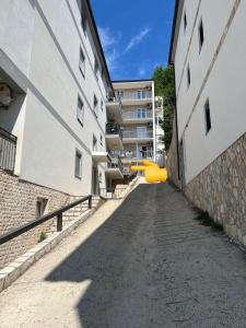 an alley between two buildings with a yellow slide at Smart Bijela in Bijela