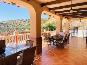 a patio with tables and chairs on a balcony at Villa Arcoiris At Home in Torrox