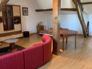 a living room with a red couch and a bed at Appartement au calme avec Wifi, en Brenne - FR-1-591-754 in Saint-Gaultier