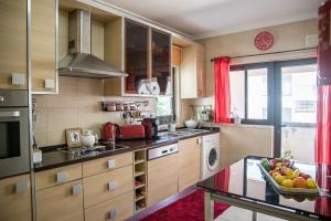 a kitchen with a bowl of fruit on a table at Apartamento Dubai By Garvetur in Quarteira +5 photos