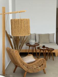 a living room with a wicker chair and a couch at Sea Bliss Adults Only in Parga