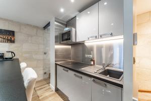 a kitchen with a sink and a microwave at Superbe Duplex en Hypercentre avec Rooftop et Climatisation in Bordeaux