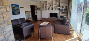 Una sala de estar con dos sillas y un televisor. en Villa des Collines, en Malmedy