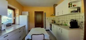 Una cocina con gabinetes blancos y un refrigerador blanco. en Villa des Collines, en Malmedy