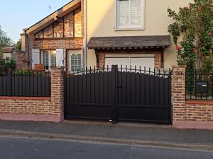 a black gate in front of a house at Appartement indépendant à Saran, proche Orléans - FR-1-590-574 in Saran