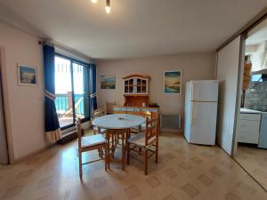 une cuisine avec une table, des chaises et un réfrigérateur dans l'établissement Appartement T2 au centre de Vieux-Boucau avec parking privé, proche des plages - FR-1-239-1136, à Vieux-Boucau-les-Bains 5 autres photos