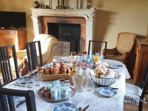 un tavolo con piatto di cibo e un camino di Maison d'hôtes familiale près de La Flèche, animaux acceptés - FR-1-410-476 a Cré-sur-Loir