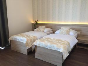 zwei Betten, die in einem Zimmer nebeneinander stehen in der Unterkunft Hotel Samaria in Šamorín