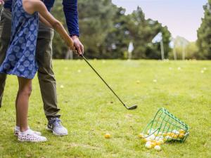 un hombre y una niña jugando al golf en un campo en Votre Havre de Paix à Merville proche de la Mer - FR-1-788-82, en Merville-Franceville-Plage