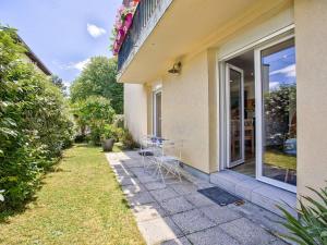 Un patio con una mesa y sillas al lado de una casa. en Votre Havre de Paix à Merville proche de la Mer - FR-1-788-82, en Merville-Franceville-Plage