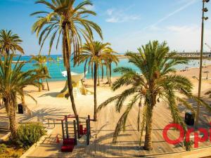 ein Strand mit Palmen und dem Meer in der Unterkunft Studio moderne avec terrasse, climatisé, WIFI, 2 couchages à Menton - FR-1-647-50 in Menton