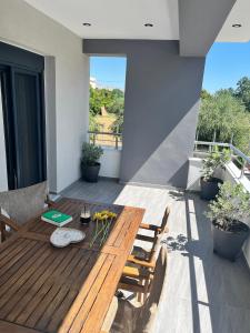 a deck with a wooden table and chairs on a balcony at La casa in Chios